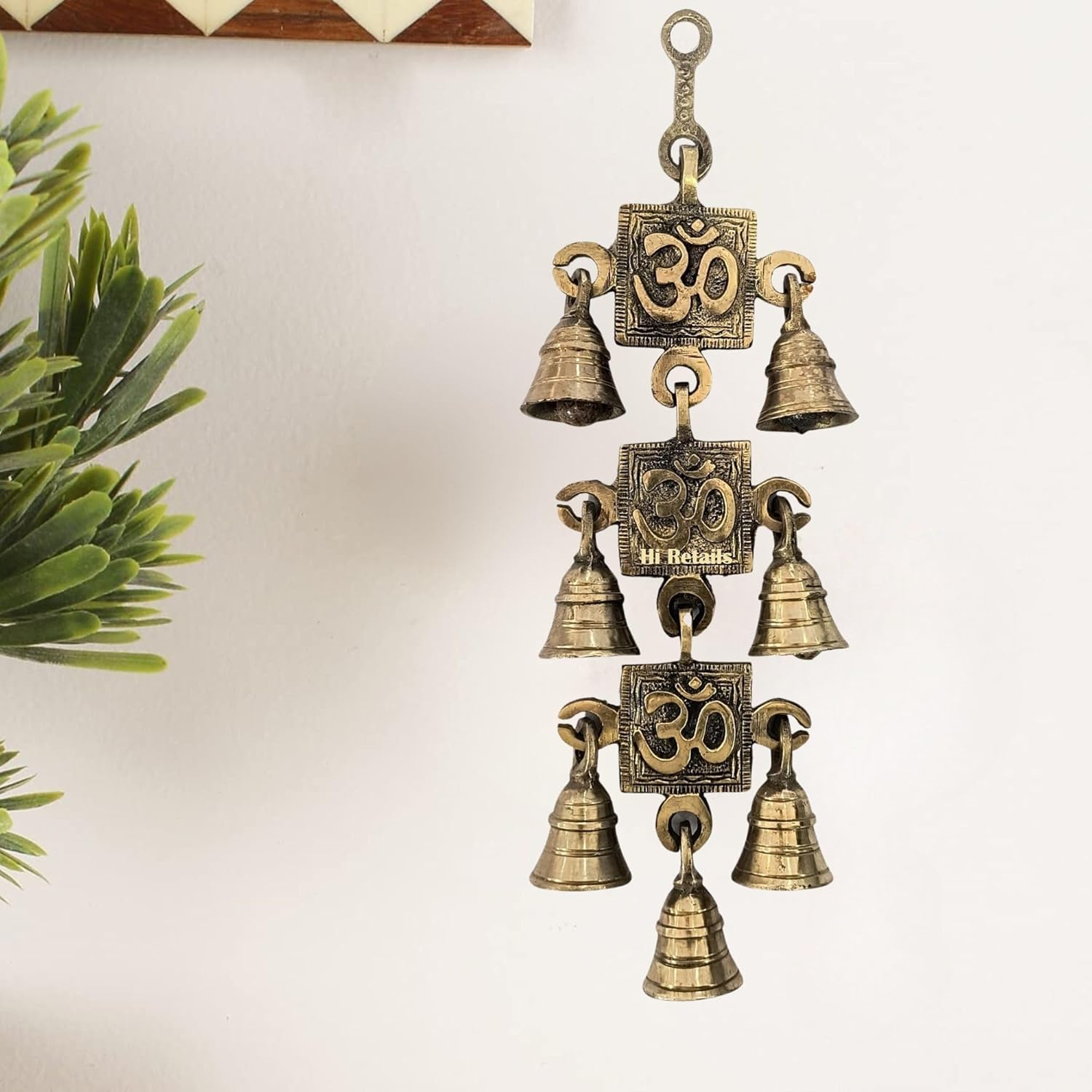 Brass hanging bells with Om symbols for temple door decor, adding spiritual elegance to your home at www.hiretails.com