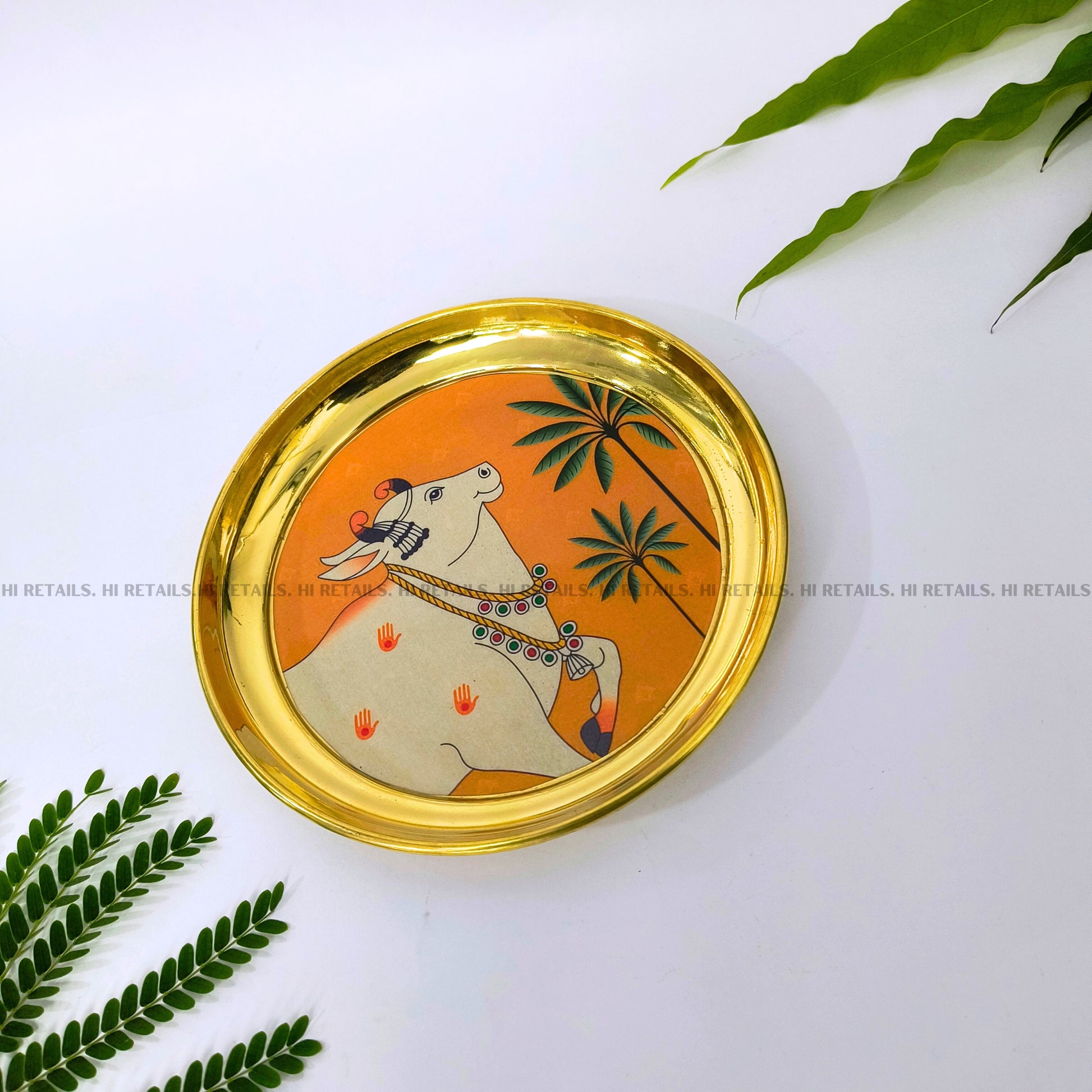 Hand-painted Pichwai cow design on a brass plate, ideal for pooja thali or home decor at www.hiretails.com